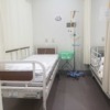 ベッドと点滴棒が写っている病室の写真
