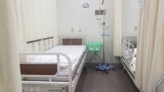 ベッドと点滴棒が写っている病室の写真