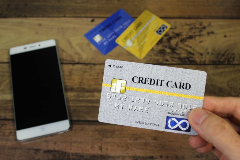 スマートフォンとクレジットカードの写真。フィッシング詐欺のイメージ画像。