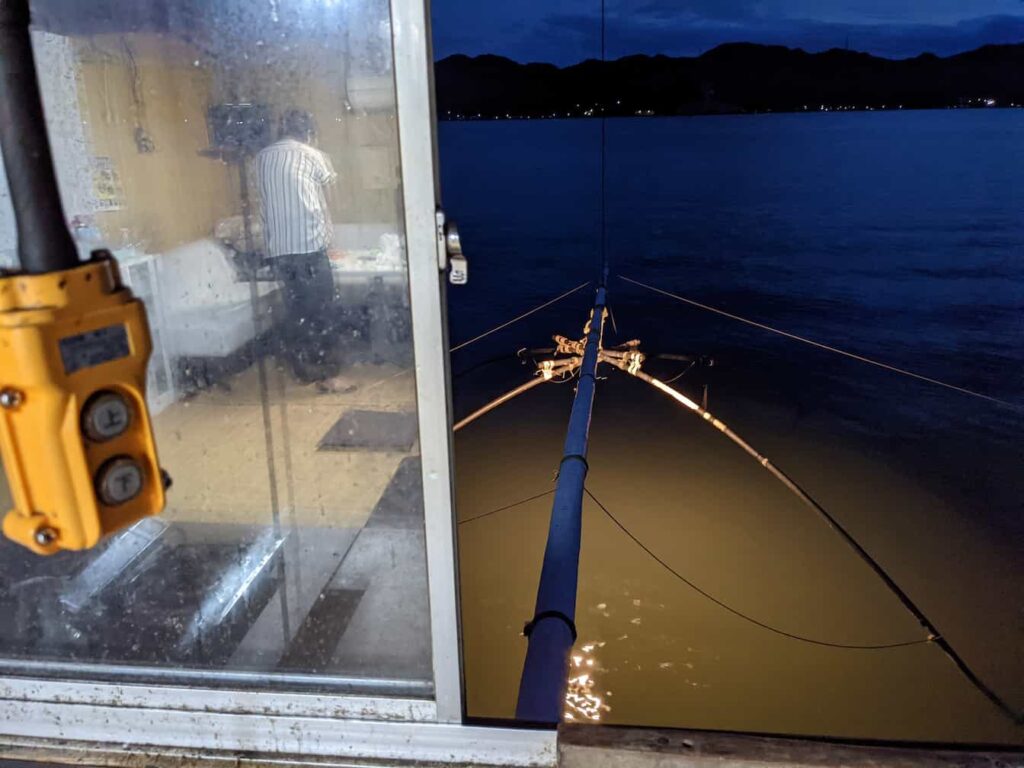 四つ手小屋から外を眺めた写真。網が海におろされて、横には網を上下させるスイッチが写っている。