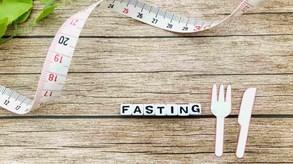 ダイエット（断食）のイメージ画像。FASTINGの文字が書かれた横にフォークとナイフのイメージ画像が描かれている。