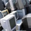 古いパソコンやディスプレイが並べられた廃棄物置き場の写真。